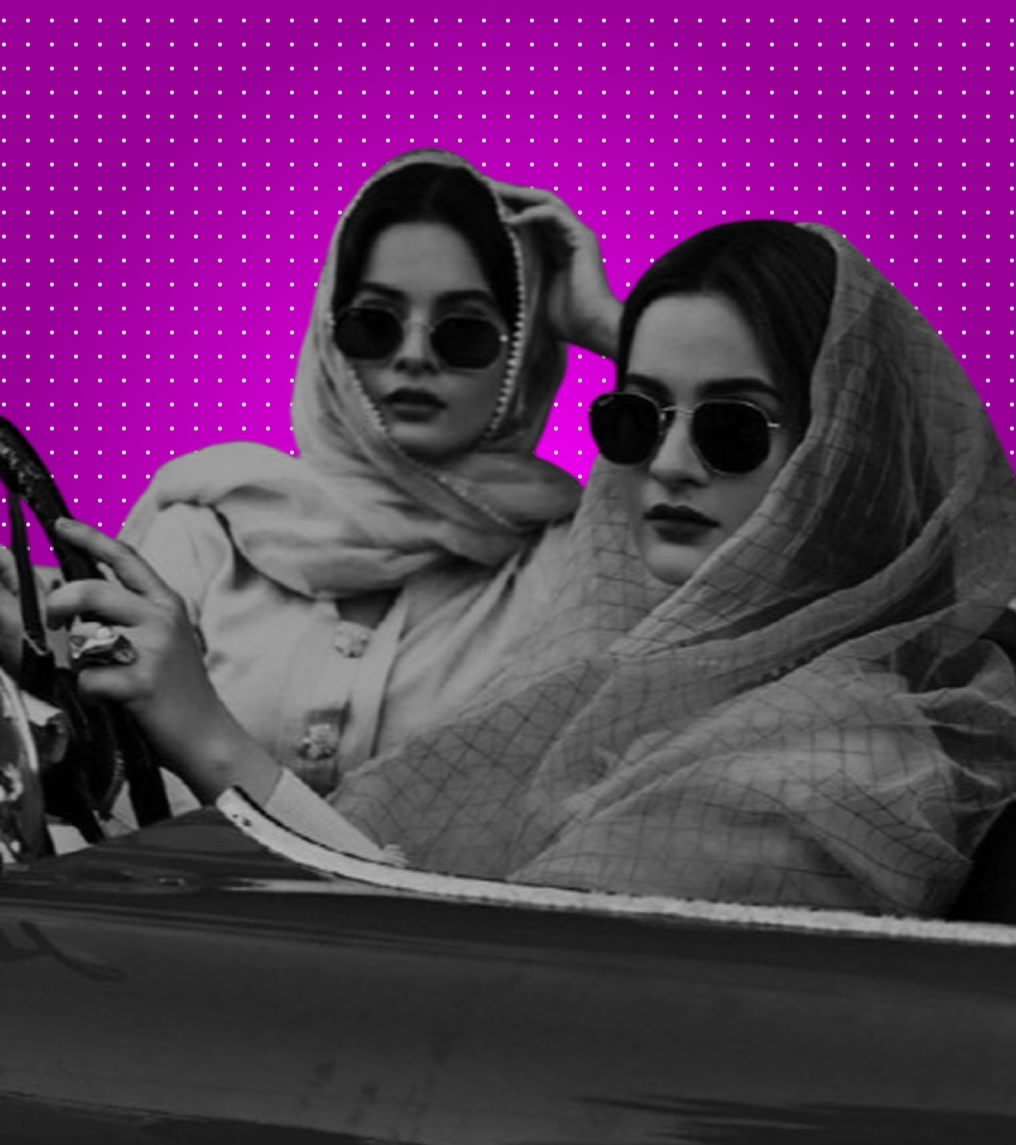 Two women in sunglasses and head scarves in vintage car style